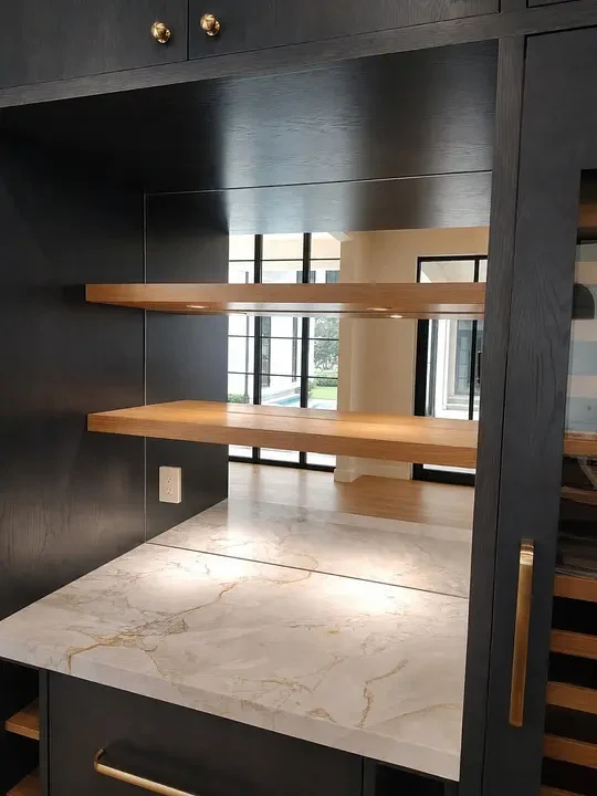 Mirrored bar backsplash with wood shelving.